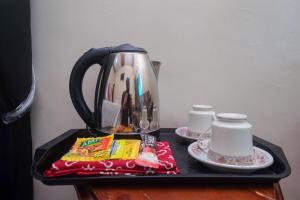 a black tray with a tea pot and cups on a table at RedDoorz Syariah near Flyover Palur in Karanganyar