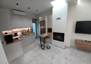 a large kitchen with a fireplace and a television at Doukas Home in Mytilene +12 photos