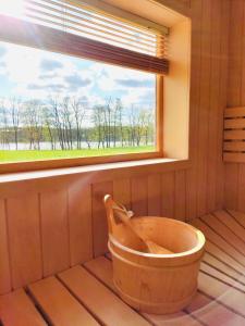 a wooden tub in a room with a window at Domek z balią in Chmielno