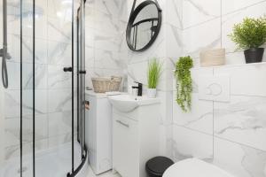 a bathroom with a shower and a toilet and a mirror at Cute & Cozy Apartment Grochowska by Renters in Warsaw