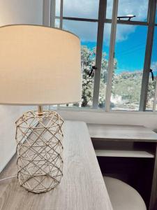 une lampe assise sur une table à côté d'une fenêtre dans l'établissement Gladstone Gem 3 - Suva CBD 2bd Apt, à Suva