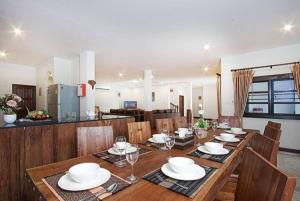 una sala da pranzo con un lungo tavolo in legno e sedie di Oriental Thai luxury villa with Private pool a Chiang Mai