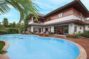 una grande piscina di fronte a una casa di Oriental Thai luxury villa with Private pool a Chiang Mai