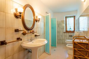 une salle de bain avec un lavabo et un miroir et des toilettes dans l'établissement Casa mia, à Castelnuovo di Garfagnana 20 autres photos
