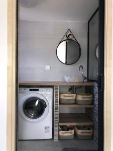 a laundry room with a washing machine and a mirror at Gîte la Pradelienne en Cévennes avec piscine privée 