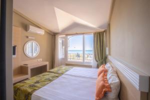 a bedroom with a bed with a view of the ocean at Akdora Elite Hotel & Spa in Side
