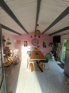 a dining room with a table and a pink wall at auxptitsbonheurs B&B in Saint-Jean-de-Monts