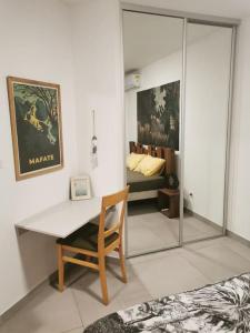 a room with a desk and a chair and a bedroom at Oasis Pied Dans L'Ô, La Saline Les Bains. in La Saline les Bains