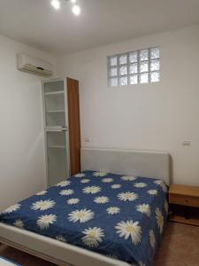 ein Schlafzimmer mit einem Bett mit einer blauen Decke mit weißen Blumen in der Unterkunft SALENTO MARE E ARTE in Nardò