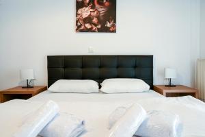 Thessaloniki Center Deluxe Apartment في سلانيك: غرفة نوم بسرير ابيض كبير ومصباحين