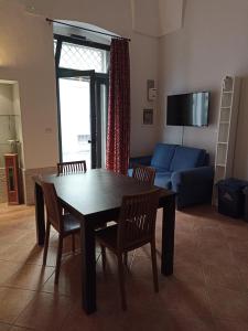 ein Wohnzimmer mit einem Tisch, Stühlen und einem blauen Sofa in der Unterkunft SALENTO MARE E ARTE in Nardò