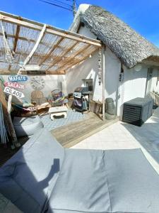 a patio of a house with a thatched roof at auxptitsbonheurs B&B in Saint-Jean-de-Monts