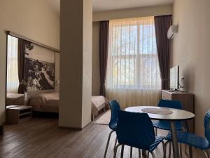 a room with a table and chairs and a bedroom at Apartamentai NIDA in Nida