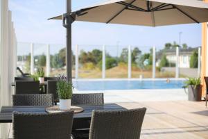 a table with chairs and an umbrella on a patio at Spa Hotel Kasnäs in Kasnäs