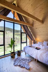sypialnia z łóżkiem w pokoju z oknami w obiekcie Osada Za gorami za lasami - domki z widokiem na Snieznik w Stroniu Śląskim