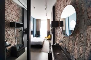 a hotel room with a mirror and a bedroom at Boutique Hotel Oosteinde in Amsterdam