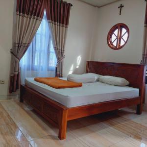 a bed in a room with a window at Kopa HillTop Family GuestHome in Ruteng