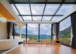 baño con ventana grande con bañera y bañera grande en Drunken Valley Manor - Zhangjiajie National Forest Park en Zhangjiajie
