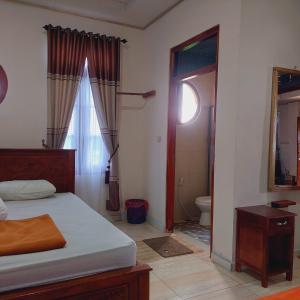 1 dormitorio con 1 cama y baño con aseo en Kopa HillTop Family GuestHome en Ruteng
