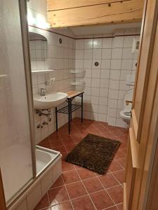 ウンケンにあるBerggasthof Hintergföllのバスルーム(シンク、バスタブ、トイレ付)