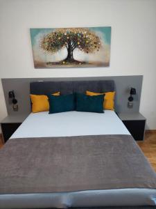 Un dormitorio con una cama grande con un árbol encima. en Apartman Stella Rossa, en Palić