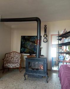 a fireplace in a room with a couch and a chair at Garden Village Home in Ayvalık