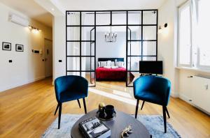 a living room with two blue chairs and a red couch at F L O R E N T I N Design Apartment ChicLife in Bergamo