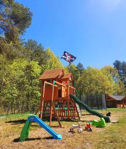 um parque infantil com um escorrega e uma estrutura de jogos em Kurdybanek - Domki letniskowe em Stegna