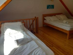 two beds in a room with wooden floors at Mézes-Kuckó in Tihany