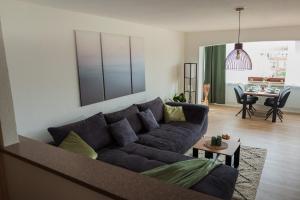 a living room with a couch and a table at Südstrand, Zentral, Balkon, Wifi, Fahrstuhl, Parken in Wilhelmshaven