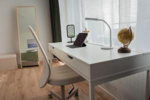 einen weißen Schreibtisch mit einem Laptop und einem Spiegel in der Unterkunft Südstrand, Zentral, Balkon, Wifi, Fahrstuhl, Parken in Wilhelmshaven