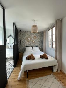 um quarto com uma cama branca e 2 toalhas castanhas em Appartement au coeur du quartier historique em Vannes
