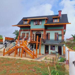 una casa con una gran escalera de madera delante de ella en Kopa HillTop Family GuestHome, en Ruteng