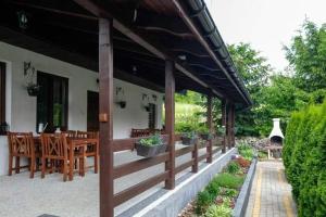 a porch of a house with wooden tables and chairs at Pokoje Irys in Kazimierz Dolny