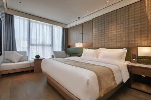 a hotel room with a large bed and a couch at Dongguan Tangxia Huaman Hotel in Dongguan