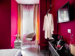 ローマにあるC'est La Vie Suitesのピンクの壁のベッドルーム(ベッド1台、ドレッサー付)