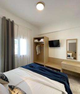 a bedroom with a large bed and a television at Vista Mare in Koutsourás