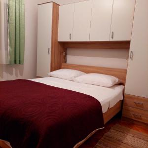 - une chambre avec un grand lit et une couverture rouge dans l'établissement Apartments Branko, à Veli Rat