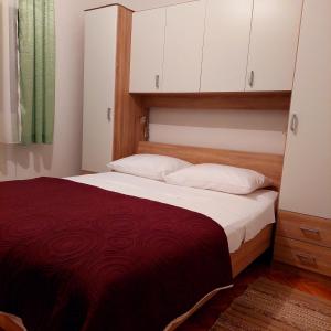 a bedroom with a large bed with a red blanket at Apartments Branko in Veli Rat