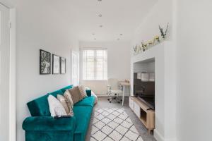 sala de estar con sofá verde y mesa en Surrey Stays - 5bed house, sleeps 12, CR5, near Gatwick Airport, en Coulsdon