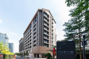 a tall building with a sign in front of it at Livetour Hotel Pazhou Exhibition Center Guangzhou in Guangzhou