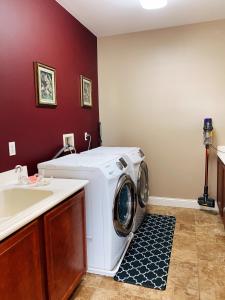 een wasmachine in een wasruimte met een wastafel bij Cozy and comfortable #201 Room in Corona
