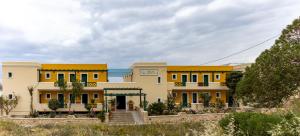 a large yellow building with stairs in front of it at Dilina Studios in Arkasa