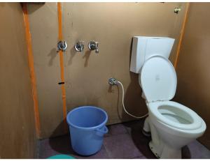 a bathroom with a toilet and a bucket at Sandeep Home stay, Chakrata in Chakrāta