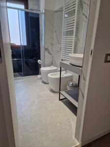 uma casa de banho com 2 lavatórios, um WC e um chuveiro em Residence Laura em Cesano Boscone