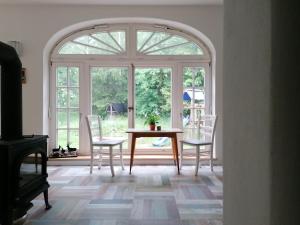 a dining room with an arched window and a table and chairs at Villa Viriditas in Elbingerode