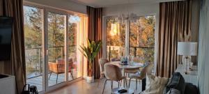 salon ze stołem i krzesłami oraz dużym oknem w obiekcie Marina View 15 & SPA w Dziwnowie