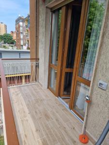 einen Balkon mit einer Holztür und einer Glastür in der Unterkunft Residence Laura in Cesano Boscone