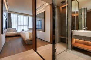 a bathroom with a bed and a sink and a mirror at Dongguan Tangxia Huaman Hotel in Dongguan