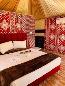 Schlafzimmer mit einem großen Bett mit roten und weißen Wänden in der Unterkunft Areen camp, Wadi Rum in Wadi Rum